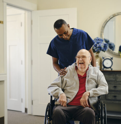 Caregiver helps elder patient who just return from hospital feeling comfortable at his home.