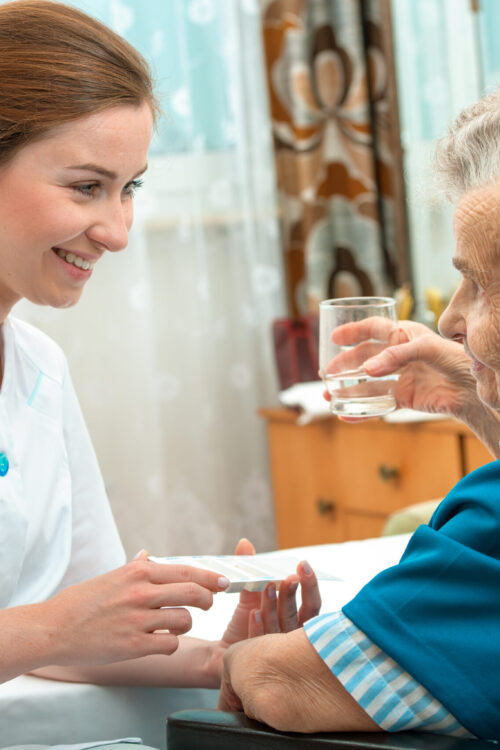 Caregiver help elder patient with dementia with her medications. Caregiver help elder patient with dementia with her medications.