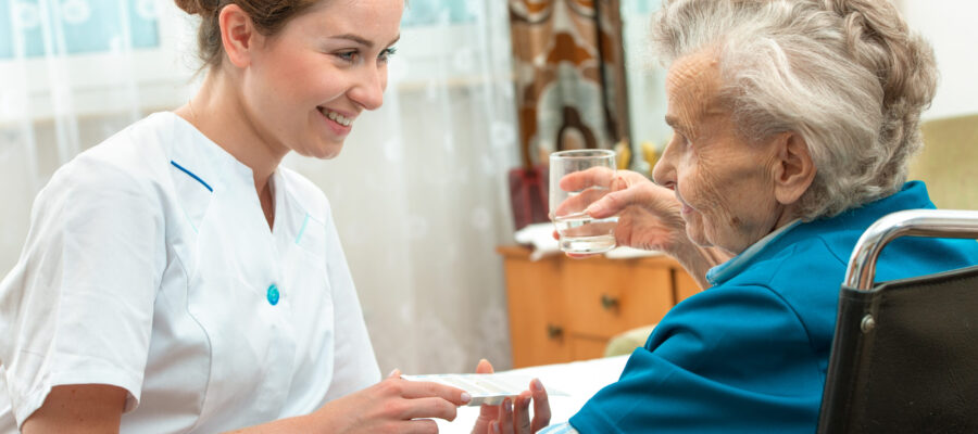 female nurse giving senior woman medical pills