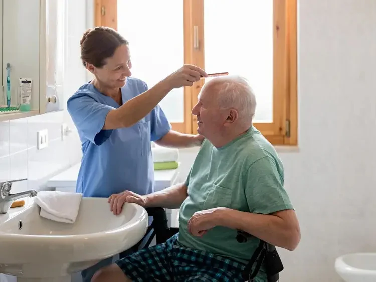 Caregiver assisting an older adult with dementia during bathing and dressing support